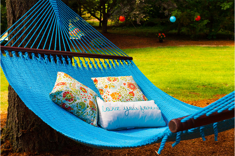 An outdoor hammock adorned with beautiful pillows, adding comfort and style to the serene setting.