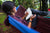 a woman kying down in her hammock in the forrest, writing in her diary